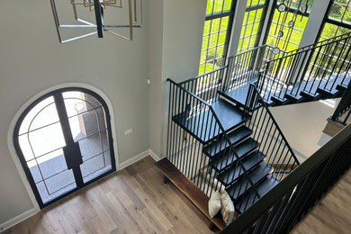 Photo of a traditional front door in Detroit with grey walls, light hardwood flooring, a double front door, a black front door and beige floors.