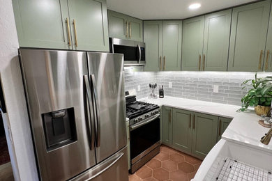 Trendy u-shaped ceramic tile and orange floor kitchen photo in San Diego with a farmhouse sink, shaker cabinets, green cabinets, quartz countertops, gray backsplash, subway tile backsplash, stainless steel appliances and white countertops