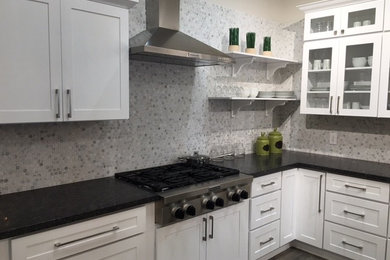 Photo of a mid-sized transitional l-shaped separate kitchen in Orange County with white cabinets, grey splashback, mosaic tile splashback, stainless steel appliances, dark hardwood floors, shaker cabinets, granite benchtops, with island and grey floor.