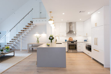 Kitchen - mid-sized contemporary laminate floor and brown floor kitchen idea in New York with an undermount sink, flat-panel cabinets, white cabinets, quartz countertops, white backsplash, ceramic backsplash and stainless steel appliances