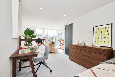 Ejemplo de habitación infantil unisex de 4 a 10 años y blanca minimalista de tamaño medio con escritorio, paredes blancas, moqueta, suelo gris, papel pintado y papel pintado