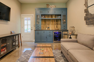 Inspiration for a mid-sized rustic enclosed concrete floor living room remodel in Austin with a bar, beige walls and a wall-mounted tv