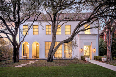 This is an example of a large contemporary two-storey brick white house exterior in Dallas with a gable roof and a tile roof.