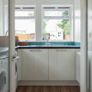 他の地域の中サイズのコンテンポラリースタイルのおしゃれな洗濯室 (ダブルシンク、フラットパネル扉のキャビネット、白いキャビネット、白い壁、無垢フローリング、左右配置の洗濯機・乾燥機) の写真
