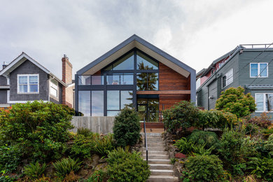 Mid-sized trendy brown two-story wood house exterior photo in Seattle with a black roof