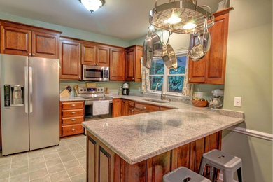 Mid-sized elegant u-shaped ceramic tile and gray floor eat-in kitchen photo in Other with a single-bowl sink, raised-panel cabinets, medium tone wood cabinets, stainless steel appliances, a peninsula, granite countertops and stone slab backsplash