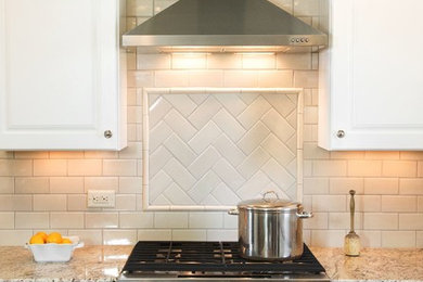 Eat-in kitchen - small traditional l-shaped light wood floor eat-in kitchen idea in Nashville with an undermount sink, raised-panel cabinets, white cabinets, granite countertops, white backsplash, ceramic backsplash, stainless steel appliances and no island