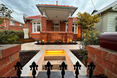 Small traditional front yard full sun garden in Melbourne with a garden path, natural stone pavers and a metal fence for spring.