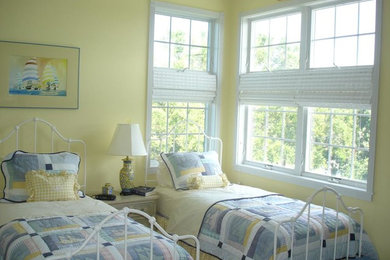 Photo of a mid-sized beach style guest bedroom in Other with yellow walls and carpet.