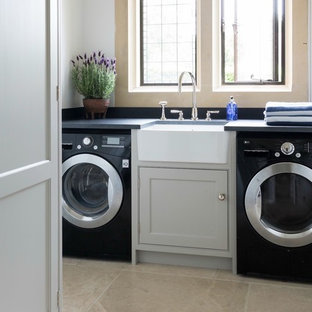 Foto de cuarto de lavado lineal, moderno, pequeño, con fregadero sobremueble, puertas de armario grises, encimera de esteatita, paredes grises, suelo de baldosas de cerámica, lavadora y secadora juntas, suelo beige y armarios con rebordes decorativos