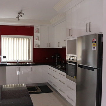 Red splashback with white cabinets