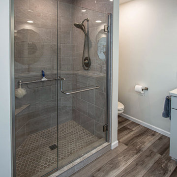 Waypoint Gray Shaker Door Cabinetry with Tiled Shower and Matching Tub Surround
