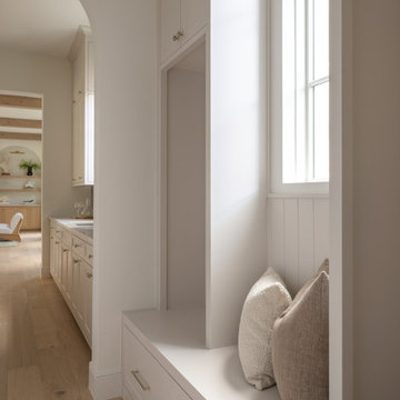 Mudroom bench with built-in storage beneath a transom window