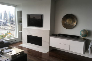 Living room - mid-sized contemporary dark wood floor and white floor living room idea in Vancouver with white walls, a standard fireplace, a stone fireplace and a media wall