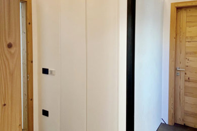 Modelo de armario y vestidor unisex actual de tamaño medio con a medida, armarios con paneles lisos y puertas de armario blancas