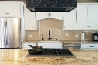 Example of a transitional open concept kitchen design in San Diego with a farmhouse sink, shaker cabinets, white cabinets, granite countertops, beige backsplash, ceramic backsplash, stainless steel appliances, an island and beige countertops