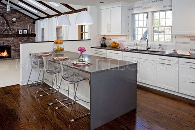 Inspiration for a mid-sized transitional u-shaped dark wood floor enclosed kitchen remodel in Philadelphia with an undermount sink, flat-panel cabinets, white cabinets, quartzite countertops, white backsplash, subway tile backsplash, stainless steel appliances and an island