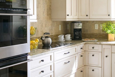 Inspiration for a mid-sized transitional l-shaped medium tone wood floor and brown floor kitchen remodel in DC Metro with stone tile backsplash, beige backsplash, recessed-panel cabinets, an undermount sink, white cabinets, stainless steel appliances and an island