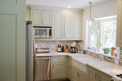 Example of a small arts and crafts u-shaped medium tone wood floor and brown floor enclosed kitchen design in Atlanta with a farmhouse sink, shaker cabinets, green cabinets, quartzite countertops, multicolored backsplash, matchstick tile backsplash, stainless steel appliances and a peninsula