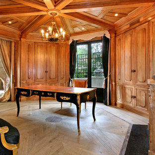 Mediterranean home office and library in Orange County with light hardwood flooring, a freestanding desk and beige floors.