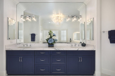 Идея дизайна: большая главная ванная комната в стиле неоклассика (современная классика) с фасадами в стиле шейкер, синими фасадами, накладной ванной, двойным душем, унитазом-моноблоком, белой плиткой, керамогранитной плиткой, белыми стенами, полом из керамогранита, врезной раковиной, столешницей из искусственного кварца, белым полом, душем с распашными дверями, синей столешницей, сиденьем для душа, тумбой под две раковины и встроенной тумбой