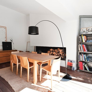 Idées déco pour une salle à manger contemporaine avec un mur blanc, un sol en bois foncé et une cheminée standard.