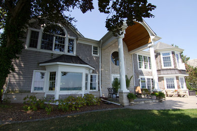 Large traditional gray two-story wood exterior home idea in Detroit