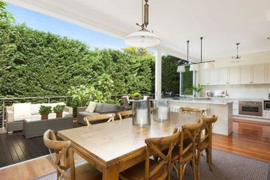 Photo of a large traditional open plan dining in Sydney with white walls and medium hardwood floors.