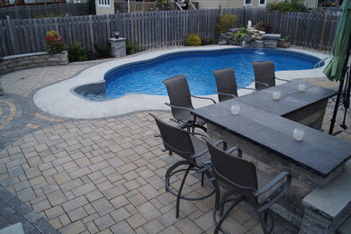 Large transitional backyard concrete paver pool fountain photo in Ottawa