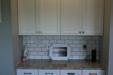 Mid-sized cottage ceramic tile kitchen photo in Other with an undermount sink, shaker cabinets, white cabinets, granite countertops, white backsplash, subway tile backsplash, stainless steel appliances and a peninsula