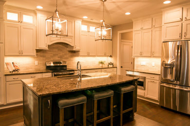 Open concept kitchen - large traditional l-shaped dark wood floor open concept kitchen idea in Other with an undermount sink, recessed-panel cabinets, white cabinets, granite countertops, beige backsplash, matchstick tile backsplash, stainless steel appliances and an island