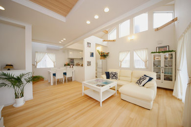 Photo of a mid-sized beach style formal open concept living room in Other with white walls, light hardwood floors, no fireplace, a freestanding tv and beige floor.