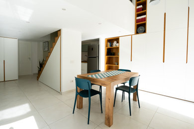 Immagine di una piccola sala da pranzo aperta verso il soggiorno design con pareti bianche e pavimento in gres porcellanato