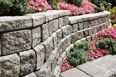 Inspiration for a large traditional courtyard full sun formal garden for summer in Toronto with a retaining wall and natural stone pavers.