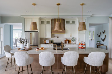 Inspiration for a coastal galley light wood floor and beige floor open concept kitchen remodel in Baltimore with an undermount sink, shaker cabinets, white cabinets, marble countertops, white backsplash, subway tile backsplash, stainless steel appliances, an island and multicolored countertops