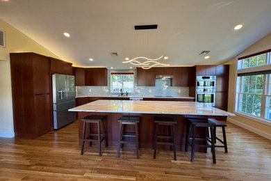 Large minimalist l-shaped vaulted ceiling and medium tone wood floor kitchen photo in Boston with an undermount sink, quartz countertops, blue backsplash, stainless steel appliances, an island, flat-panel cabinets, dark wood cabinets, ceramic backsplash and white countertops
