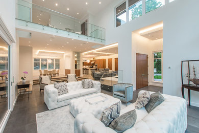 Mid-sized trendy open concept concrete floor and gray floor family room photo in Vancouver with white walls, no fireplace and no tv