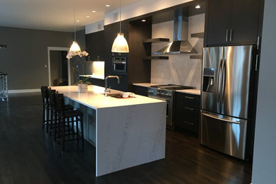 Inspiration for a large contemporary single-wall dark wood floor open concept kitchen remodel in Chicago with an undermount sink, flat-panel cabinets, dark wood cabinets, quartzite countertops, white backsplash, stone tile backsplash, stainless steel appliances and an island