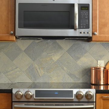 Large Slate Tile Backsplash Behind Lightly Stained Cabinets