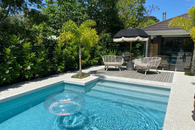Modelo de piscina actual de tamaño medio en patio trasero