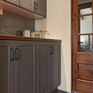 Exempel på ett stort amerikanskt brun linjärt brunt skafferi, med skåp i shakerstil, grå skåp, träbänkskiva, grått stänkskydd, stänkskydd i tunnelbanekakel, klinkergolv i terrakotta och brunt golv