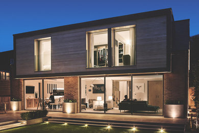 Foto de fachada de casa contemporánea de dos plantas con revestimiento de madera