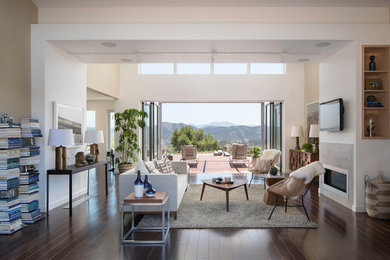 Inspiration for a huge contemporary open concept dark wood floor living room remodel in Los Angeles with white walls, a standard fireplace, a tile fireplace and a wall-mounted tv