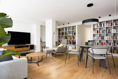 Modelo de biblioteca en casa abierta actual grande sin chimenea con suelo laminado