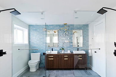 Large trendy master blue tile and ceramic tile porcelain tile, gray floor and double-sink double shower photo in Raleigh with flat-panel cabinets, medium tone wood cabinets, a one-piece toilet, white walls, wood countertops, a vessel sink, a hinged shower door, brown countertops and a freestanding vanity
