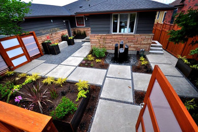 This is an example of a mid-sized contemporary front yard patio in Seattle with a water feature, concrete pavers and no cover.