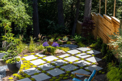 This is an example of a small midcentury side yard patio in Seattle with concrete slab.