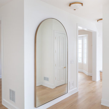 Elegant Minimalist Hallway Featuring an Arched Mirror and White Oak Floors