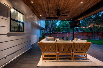 Inspiration for a mid-sized modern backyard concrete patio remodel in Dallas with a roof extension