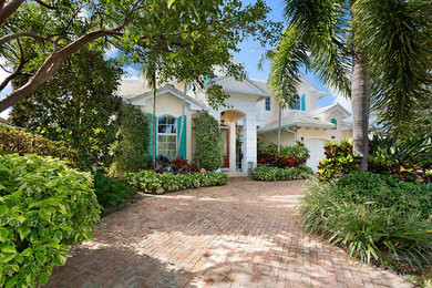 Example of a large island style beige two-story mixed siding exterior home design in Other with a mixed material roof